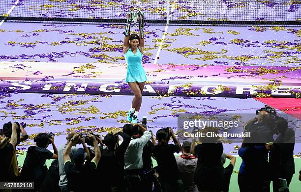 Serena Williams of the United States holds aloft the Billie Jean King Trophy as she poses for photographers after her straight sets victory against...