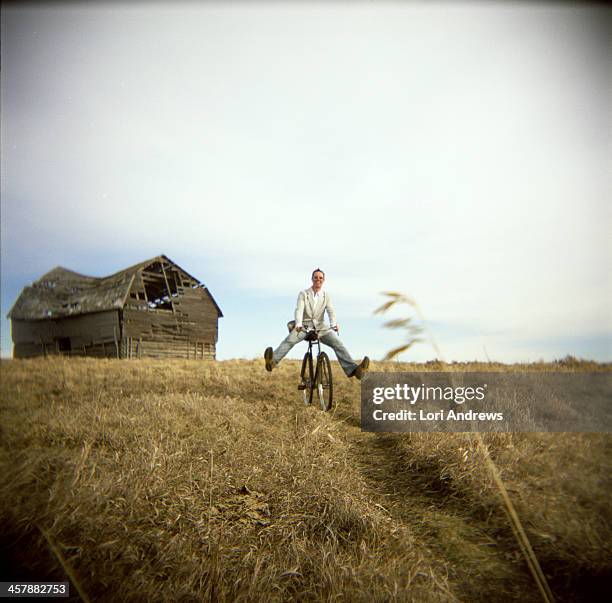 Man Riding A Bike On A Path In A Country Field, Foto stock