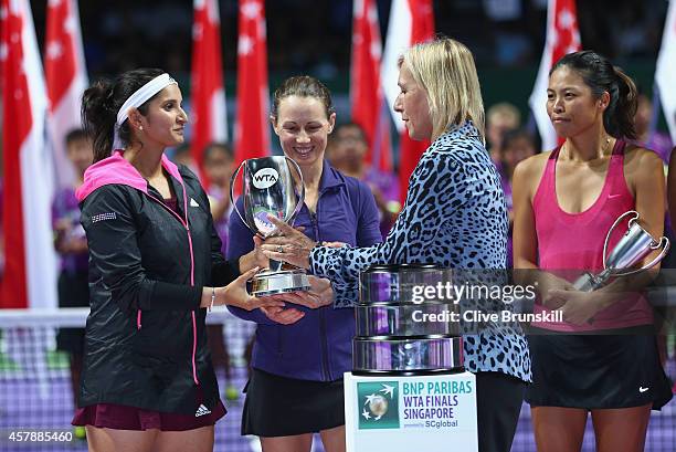 Sania Mirza of India with Martina Navratilova and the Martina Navratilova Trophy as her partner Cara Black of Zimbabwe looks on after their straight...