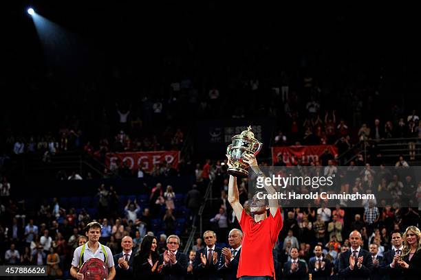 Winner Roger Federer of Switzerland lifts the trophy as runner-up David Goffin of Belgium looks on after the Swiss Indoors ATP 500 tennis tournament...