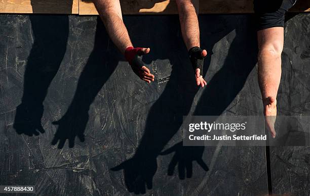 Competitors hold a hand to help during the Tough Mudder London South on October 25, 2014 in Winchester, England. The world-famous Tough Mudder is...