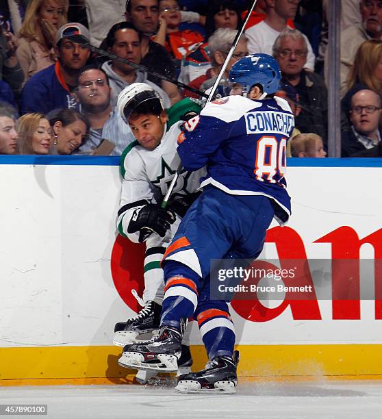 Cory Conacher of the New York Islanders hits Trevor Daley of the Dallas Stars into the boards at the Nassau Veterans Memorial Coliseum on October 25,...