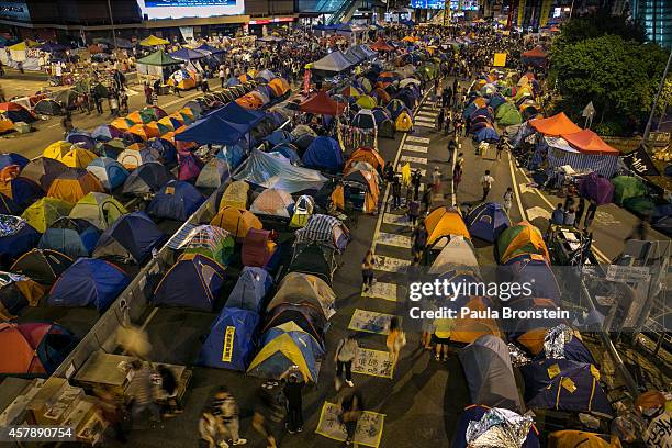 People walk amongst hundreds of tents used for campers at the main protest site as a festival atmosphere prevails October 26, 2014 in Hong Kong, Hong...