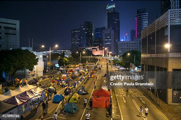 People walk amongst hundreds of tents used for campers at the main protest site as a festival atmosphere prevails October 26, 2014 in Hong Kong, Hong...