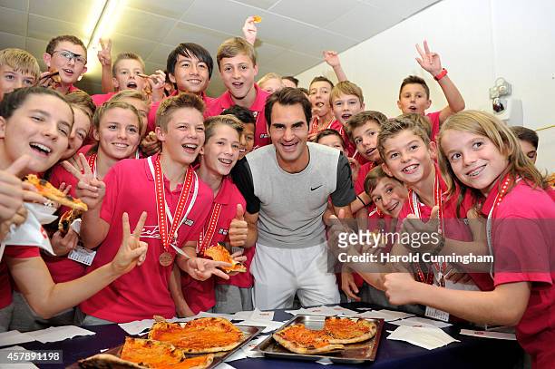 Roger Federer of Switzerland celebrates with the ball boys winning the Swiss Indoors ATP 500 tennis tournament final match against David Goffin of...