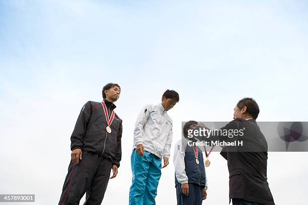 athlete receiving medal on podium - sportsperson medal stock pictures, royalty-free photos & images