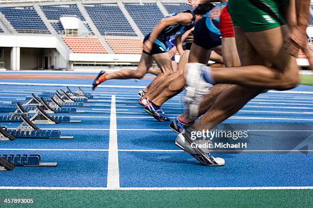 male athltes starting from blocks on track - starting block stockfoto's en -beelden