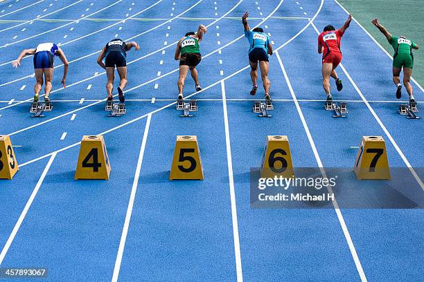 male athltes starting from blocks on track - athleticism stock pictures, royalty-free photos & images