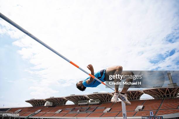 male athlete performing high jump - hochsprung stock-fotos und bilder