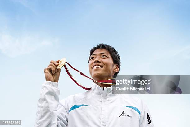 athlete smiling on podium with the medal - vincitore di medaglia foto e immagini stock