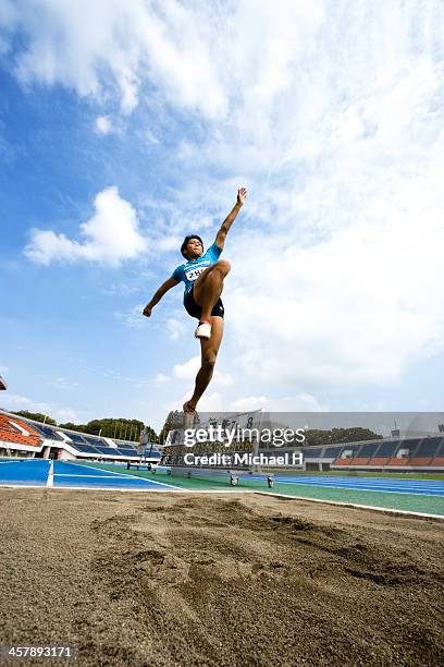 male athlete performing long jump - long jump photos et images de collection