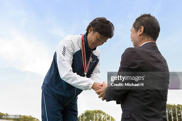 athlete receiving medal on podium - winners podium people stock pictures, royalty-free photos & images