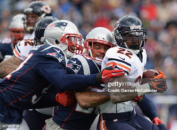 Matt Fort of the Chicago Bears is tackled by Patrick Chung of the New England Patriots during the first quarter at Gillette Stadium on October 26,...