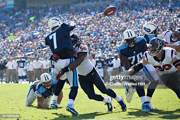 Akeem Dent of the Houston Texans hits Zach Mettenberger of the Tennessee Titans as he throws a pass at LP Field on October 26, 2014 in Nashville,...