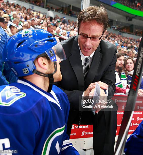 Assistant coach Doug Lidster of the Vancouver Canucks talks to Yannick Weber during their NHL game against theTampa Bay Lightning at Rogers Arena...