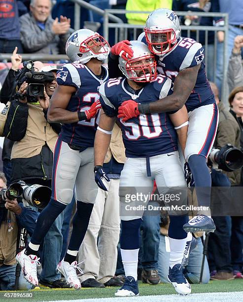 Rob Ninkovich of the New England Patriots reacts with Logan Ryan and Akeem Ayers after recovering a fumble for a touchdown during the second quarter...