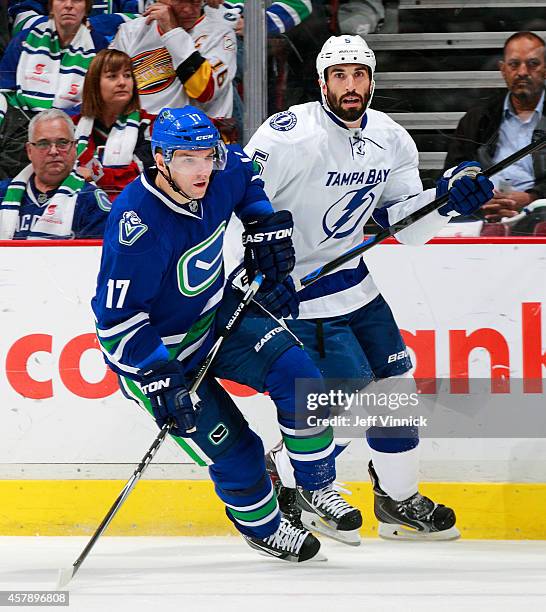 Radim Vrbata of the Vancouver Canucks and Jason Garrison of the Tampa Bay Lightning skate up ice during their NHL game at Rogers Arena October 18,...
