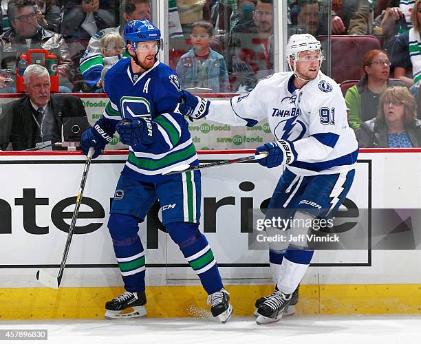 Daniel Sedin of the Vancouver Canucks and Steven Stamkos of the Tampa Bay Lightning skate up ice during their NHL game at Rogers Arena October 18,...