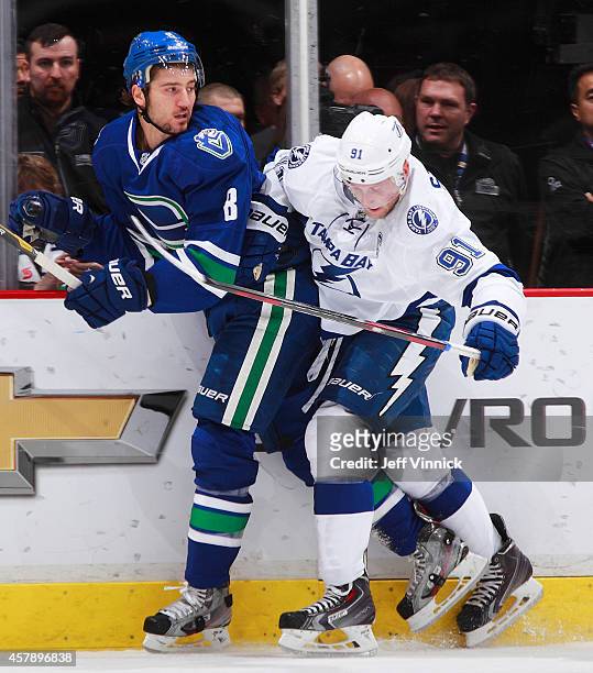 Christopher Tanev of the Vancouver Canucks and Steven Stamkos of the Tampa Bay Lightning battle along the boards during their NHL game at Rogers...