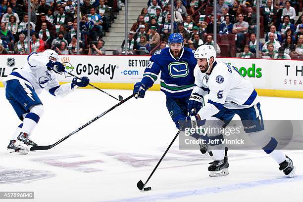 Chris Higgins of the Vancouver Canucks and Jason Garrison of the Tampa Bay Lightning skate up ice during their NHL game at Rogers Arena October 18,...