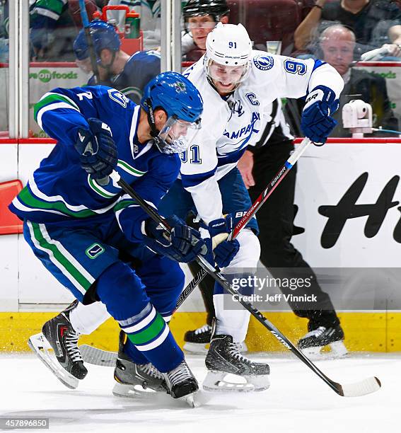 Dan Hamhuis of the Vancouver Canucks and Steven Stamkos of the Tampa Bay Lightning battle along the boards during their NHL game at Rogers Arena...