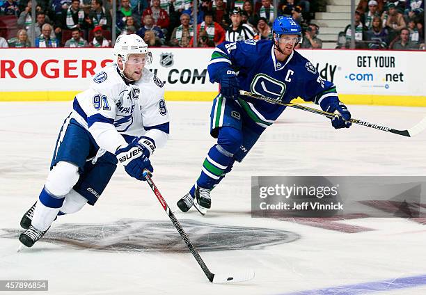 Steven Stamkos of the Tampa Bay Lightning and Henrik Sedin of the Vancouver Canucks skate up ice during their NHL game at Rogers Arena October 18,...