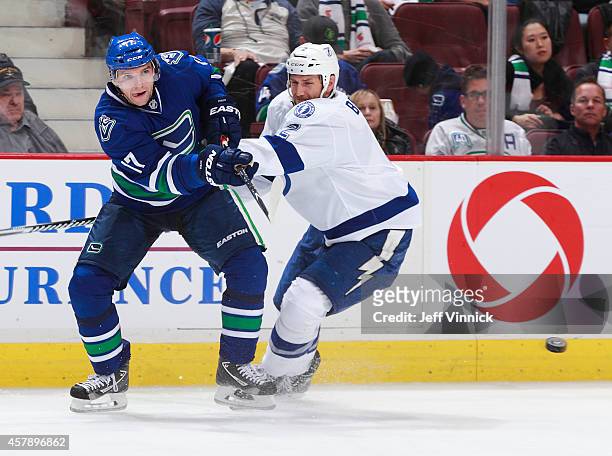 Radim Vrbata of the Vancouver Canucks passes the puck up ice past Eric Brewer of the Tampa Bay Lightning during their NHL game at Rogers Arena...