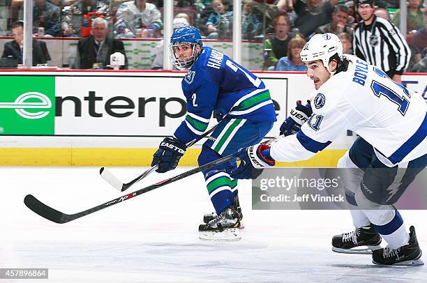 Dan Hamhuis of the Vancouver Canucks and Brian Boyle of the Tampa Bay Lightning skate up ice during their NHL game at Rogers Arena October 18, 2014...