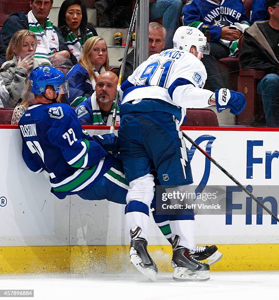Steven Stamkos of the Tampa Bay Lightning checks Daniel Sedin of the Vancouver Canucks into the boards during their NHL game at Rogers Arena October...