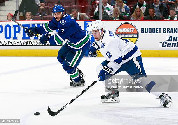 Tyler Johnson of the Tampa Bay Lightning and Christopher Tanev of the Vancouver Canucks skate up ice during their NHL game at Rogers Arena October...