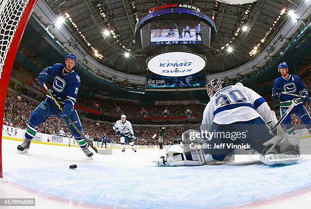 Ben Bishop of the Tampa Bay Lightning makes a save as Nick Bonino of the Vancouver Canucks looks for a rebound during their NHL game at Rogers Arena...