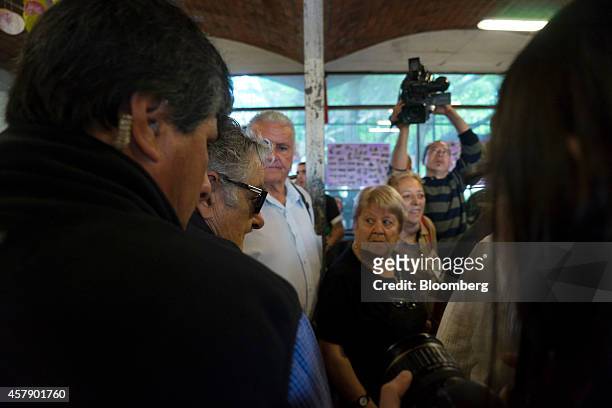Jose Mujica, Uruguay's president, center in sunglasses, arrives at a polling station in Montevideo, Uruguay, on Sunday, Oct. 26, 2014. Polls show the...