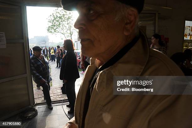 People wait at a polling station in Montevideo, Uruguay, on Sunday, Oct. 26, 2014. Polls show the vote will probably go to a second round on Nov. 30...