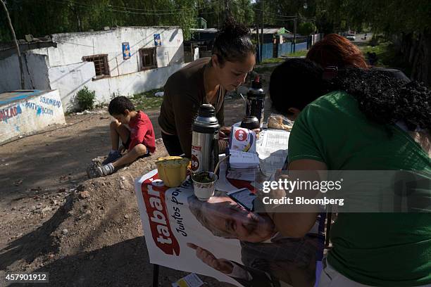 Broad Front party supporters check lists in the Cachimba del Piojo neighborhood of Montevideo, Uruguay, on Sunday, Oct. 26, 2014. Polls show the vote...