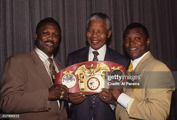 Joe Frazier, Nelson Mandela and boxing promoter Butch Lewis as Frazier gives Nelson Mandela his heavyweight belt on July 1992 at the Helmsley Hotel...