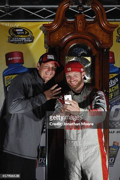 Dale Earnhardt Jr., driver of the National Guard Chevrolet, right, and crew chief Steve Letarte, take a selfie with the trophy after their victory in...