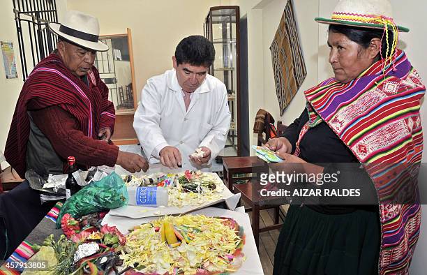 The director of the Agromont Hospital, Jaime Agramont and two "Amautas" prepare a table to call the "Ajayu" of a patient on December 5, 2013 in El...