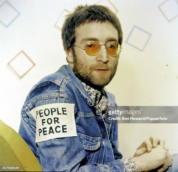 English musician and former member of The Beatles John Lennon posed backstage in London on 11th February 1970. John Lennon is wearing a denim jacket...