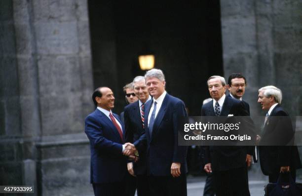 Italian Prime Minister Silvio Berlusconi shakes hands with 42nd President of the United States Bill Clinton, on the right US Secretary of State...