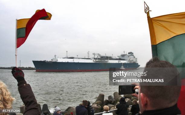 People wave national flags as they welcome the first liquefied natural gas terminal "Independence" in the port of Klaipeda on October 27, 2014. The...