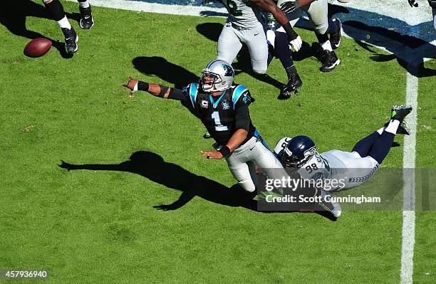 Cam Newton of the Carolina Panthers flips the ball away as he is pressured by Greg Scruggs of the Seattle Seahawks on October 26, 2014 at Bank of...