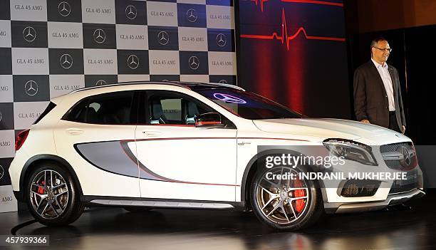 Mercedes-Benz India Managing Director Eberhard Kern poses with the new GLA45 AMG 4Matic car during its launch in Mumbai on October 27, 2014. The...