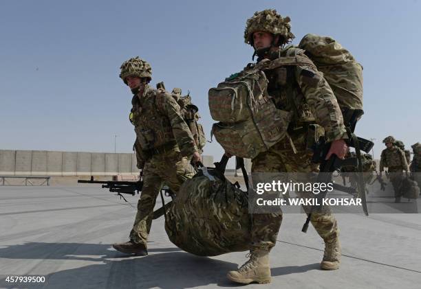 British soldiers walk with their gear after arriving in Kandahar on October 27 as British and US forces withdraw from the Camp Bastion-Leatherneck...