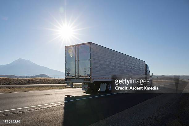 semi-trailer truck motors along empty highway - tipo di trasporto foto e immagini stock
