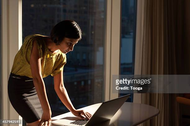 woman looking at computer late at night - leanincollection foto e immagini stock