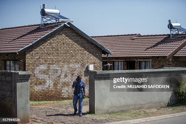 Man leaves the premises of the house where Orlando Pirate and Bafana Bafana goalkeeper Senzo Meyiwa was murdered last nigh ton October 27, 2014 in...