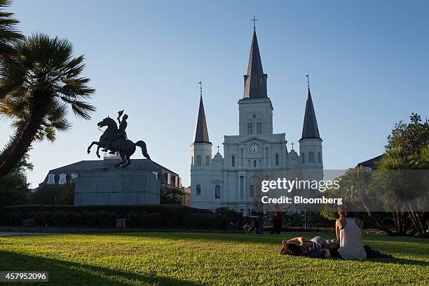 People sit in front of the St. Louis Cathedral at Jackson Square in the French Quarter in New Orleans, Louisiana, U.S., on Wednesday, Oct. 22, 2014....