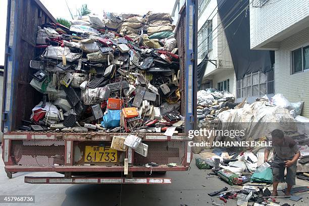 China-economy-technology-environment-lifestyle,newseries-FEATURE by Felicia SONMEZ This photo taken on August 9, 2014 shows workers unloading a truck...