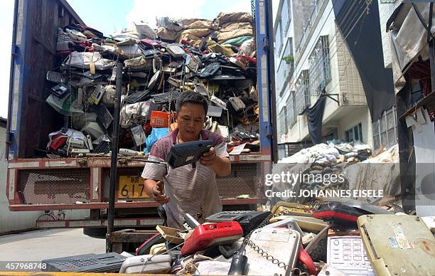 China-economy-technology-environment-lifestyle,newseries-FEATURE by Felicia SONMEZ This photo taken on August 9, 2014 shows workers unloading a truck...