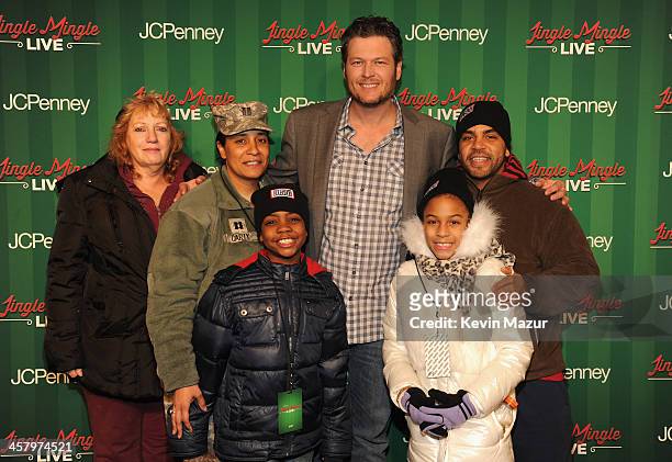 Captain Tiffany Carty and her family pose with singer Blake Shelton at a surprise holiday event and performance by Blake Shelton, with the USO Show...